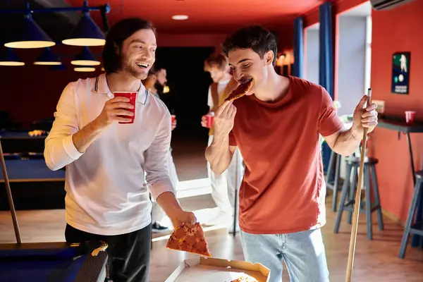 Gli amici si godono una pausa dal gioco del biliardo, mangiando pizza e bevendo bevande. — Foto stock