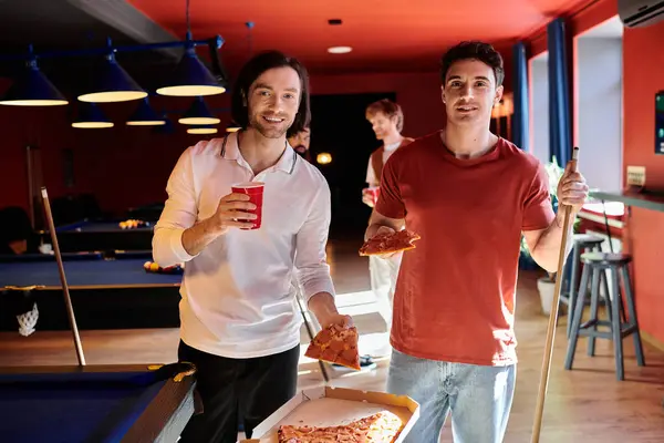 Agli amici piace la pizza e una partita a biliardo in una sala giochi informale. — Foto stock