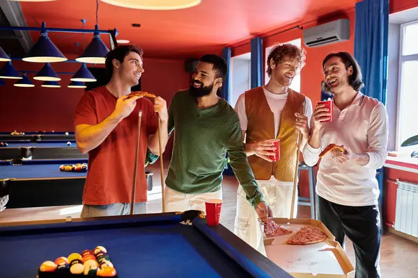 Gli amici si riuniscono intorno a un tavolo da biliardo, godendo di una partita casuale di biliardo mentre spuntano sulla pizza. — Foto stock