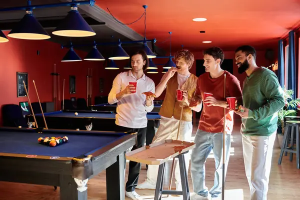 Friends casually dressed in stylish attire play pool together in a dimly lit room. — Stock Photo