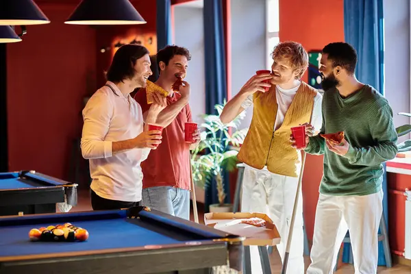 Friends gathered around a pool table, enjoying pizza and drinks. — Stock Photo