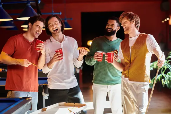Gli amici ridono e si godono la pizza giocando a biliardo. — Foto stock