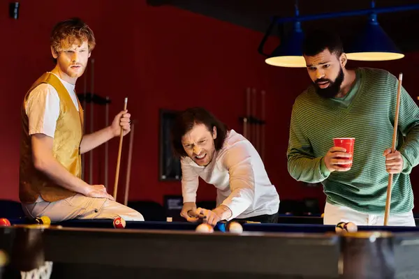 Amici giocano un gioco amichevole di biliardo in una stanza poco illuminata. — Foto stock