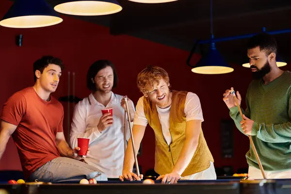 Friends play billiards in a dimly lit room. — Stock Photo