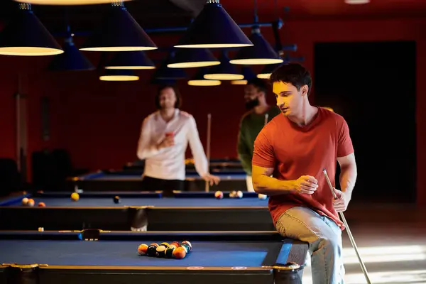 A group of friends enjoy a casual night of billiards, laughing and enjoying each others company. — Stock Photo