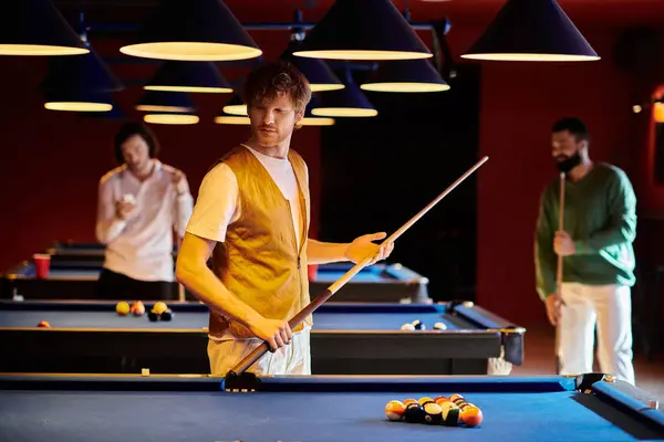 Un grupo de amigos disfruta de un amistoso juego de billar en una sala de billar cubierta. - foto de stock