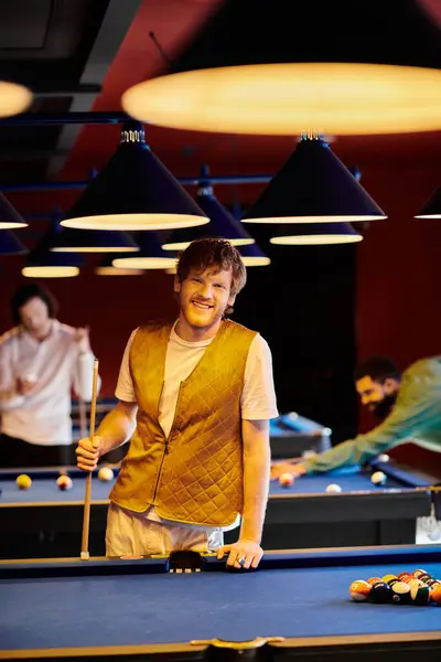 Friends play billiards in a stylishly lit setting. — Stock Photo