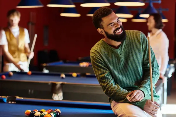 Friends enjoy a casual game of pool together in a dimly lit bar. — Stock Photo