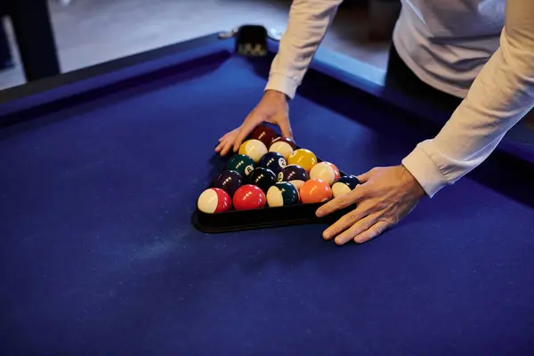 Eine Person stellt Billardkugeln auf den Tisch, bereit für ein lockeres Spiel mit Freunden. — Stockfoto