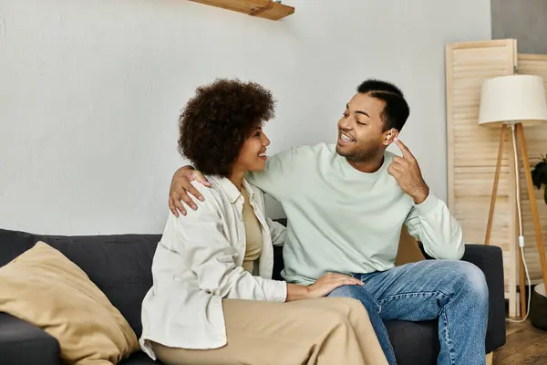 Una coppia afroamericana siede su un divano, usando il linguaggio dei segni per comunicare. — Foto stock