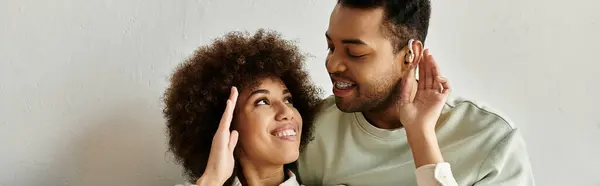An African American couple sits at home, communicating through sign language. — Stock Photo