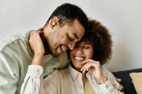 Um casal afro-americano afetuoso abraçando em casa, seus rostos iluminados de alegria e compreensão. — Fotografia de Stock