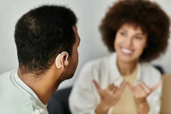 Ein junges afroamerikanisches Paar sitzt zu Hause und kommuniziert in Gebärdensprache. — Stockfoto