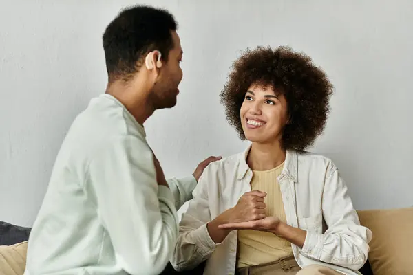 Un heureux couple afro-américain communique en utilisant la langue des signes à la maison. — Photo de stock