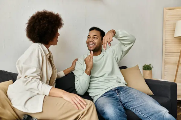 Una coppia comunica in linguaggio dei segni mentre si siede su un divano a casa. — Foto stock