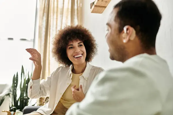 An African American couple signs to each other in their home. — Stock Photo