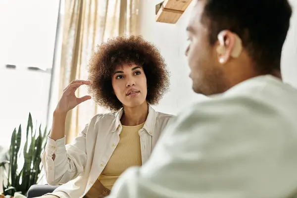 An African American couple using sign language to communicate in their living room. — Stock Photo