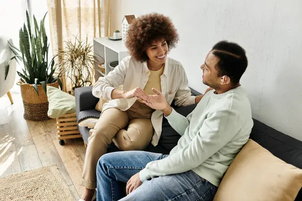 A couple sits on a couch and uses sign language to communicate. — Stock Photo