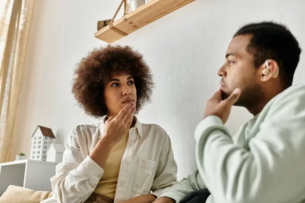 Um casal senta-se em casa, usando linguagem gestual para se comunicar uns com os outros. — Fotografia de Stock