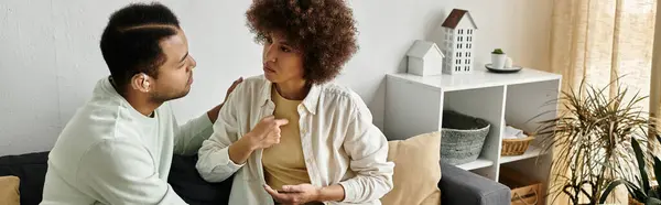 A couple sitting on a couch, using sign language to communicate. — Stock Photo