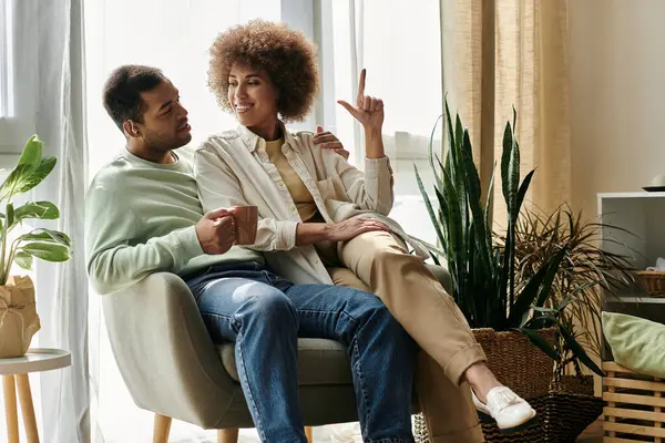 Um casal afro-americano se senta em sua casa, usando linguagem gestual para se comunicar. — Fotografia de Stock