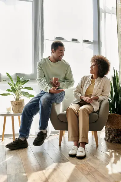 Una coppia afroamericana si siede nel loro salotto, usando il linguaggio dei segni per comunicare. — Foto stock