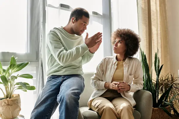 Una coppia afroamericana si siede a casa e comunica attraverso il linguaggio dei segni. — Foto stock