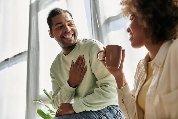 Um casal afro-americano feliz usa a linguagem gestual para se comunicar enquanto está sentado em casa. — Fotografia de Stock