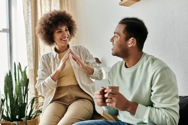 Um feliz casal afro-americano se comunica através da língua de sinais em casa. — Fotografia de Stock