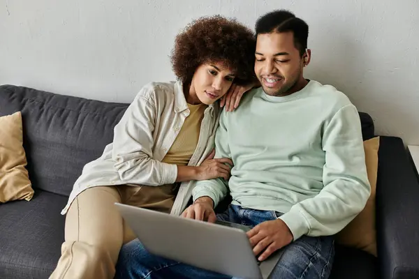 Apelando afro-americano mulher sentado perto de seu marido com aparelho auditivo e olhando para laptop. — Fotografia de Stock