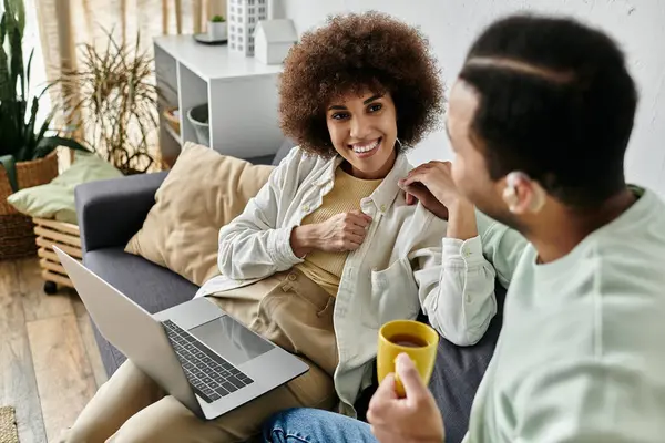 A couple uses sign language to communicate while sitting on a couch at home. — Stock Photo