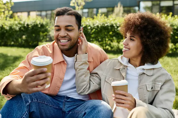 Um casal afro-americano desfruta de café e de um momento tranquilo juntos no parque. — Fotografia de Stock