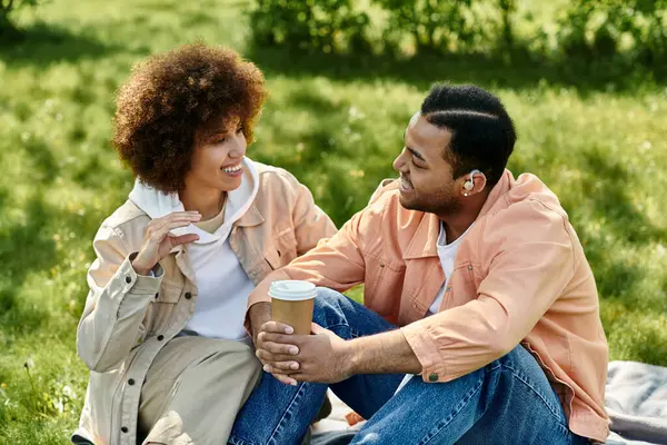 Ein afroamerikanisches Paar genießt ein Picknick im Park und kommuniziert durch Gebärdensprache. — Stockfoto