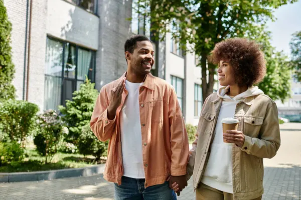 An African American couple walks hand-in-hand, communicating through sign language. — Stock Photo