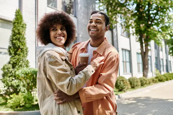 Um feliz casal afro-americano abraça enquanto caminha por uma cidade, usando a linguagem gestual para se comunicar. — Fotografia de Stock