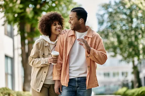 A young African American couple walking together, smiling and using sign language to communicate. — Stock Photo