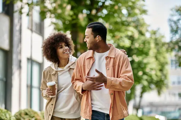 Um feliz casal afro-americano caminha pela rua, usando linguagem gestual para se comunicar. — Fotografia de Stock