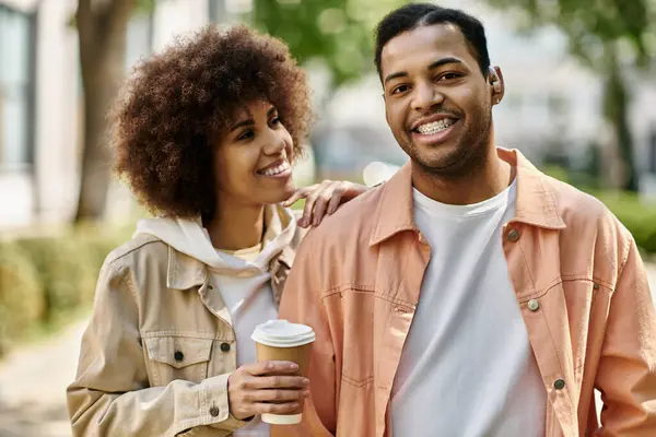 Um feliz casal afro-americano sorri ao ar livre. — Fotografia de Stock