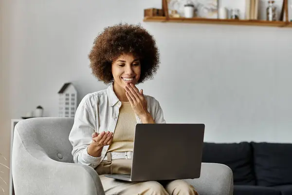 A woman smiles while using sign language on a video call. — Stock Photo