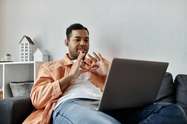 A man using sign language, next to laptop. — Stock Photo