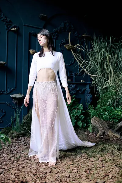 A woman in a white dress stands in a swampy environment. — Stock Photo