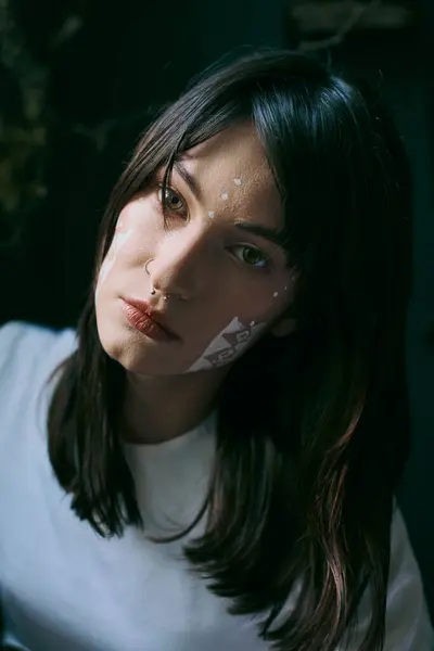 Woman with white-painted face stares at camera. — Stock Photo