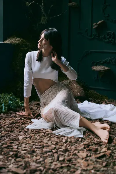 Eine Frau posiert in einem ätherischen weißen Kleid und schafft einen starken Kontrast. — Stockfoto