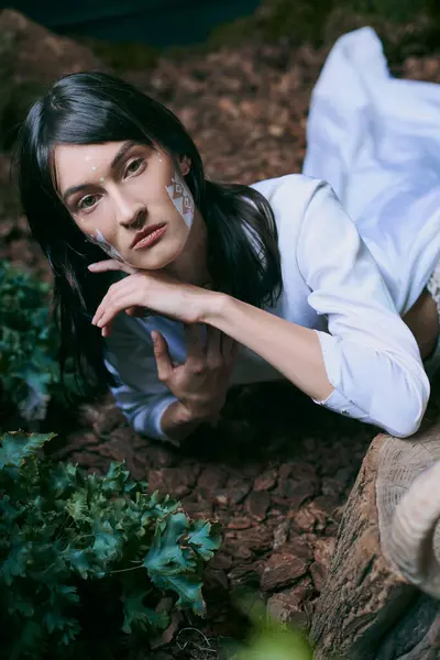 A woman in white clothing lies near a swamp. — Stock Photo