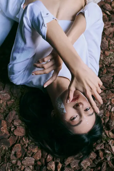 Woman in white clothes, face covered by hand. — Stock Photo