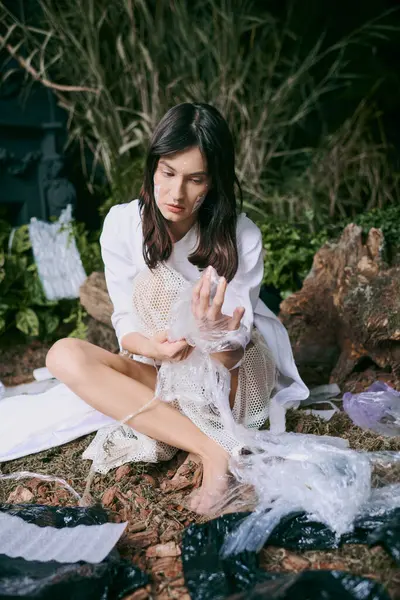 A woman poses in a swamp filled with plastic garbage, surrounded by debris. — Stock Photo