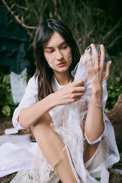 Woman poses in swamp filled with plastic, showcasing pollutions impact. — Stock Photo