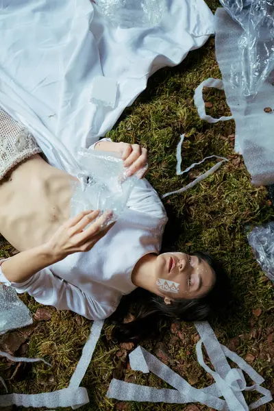 Woman lies among plastic, showing pollutions impact. — Stock Photo