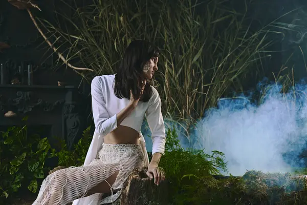A woman in white clothing poses near a swamp filled with fog. — Stock Photo