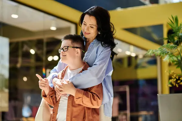 A mother and her son with Down syndrome walk through a shopping mall, enjoying quality time together. — Stock Photo